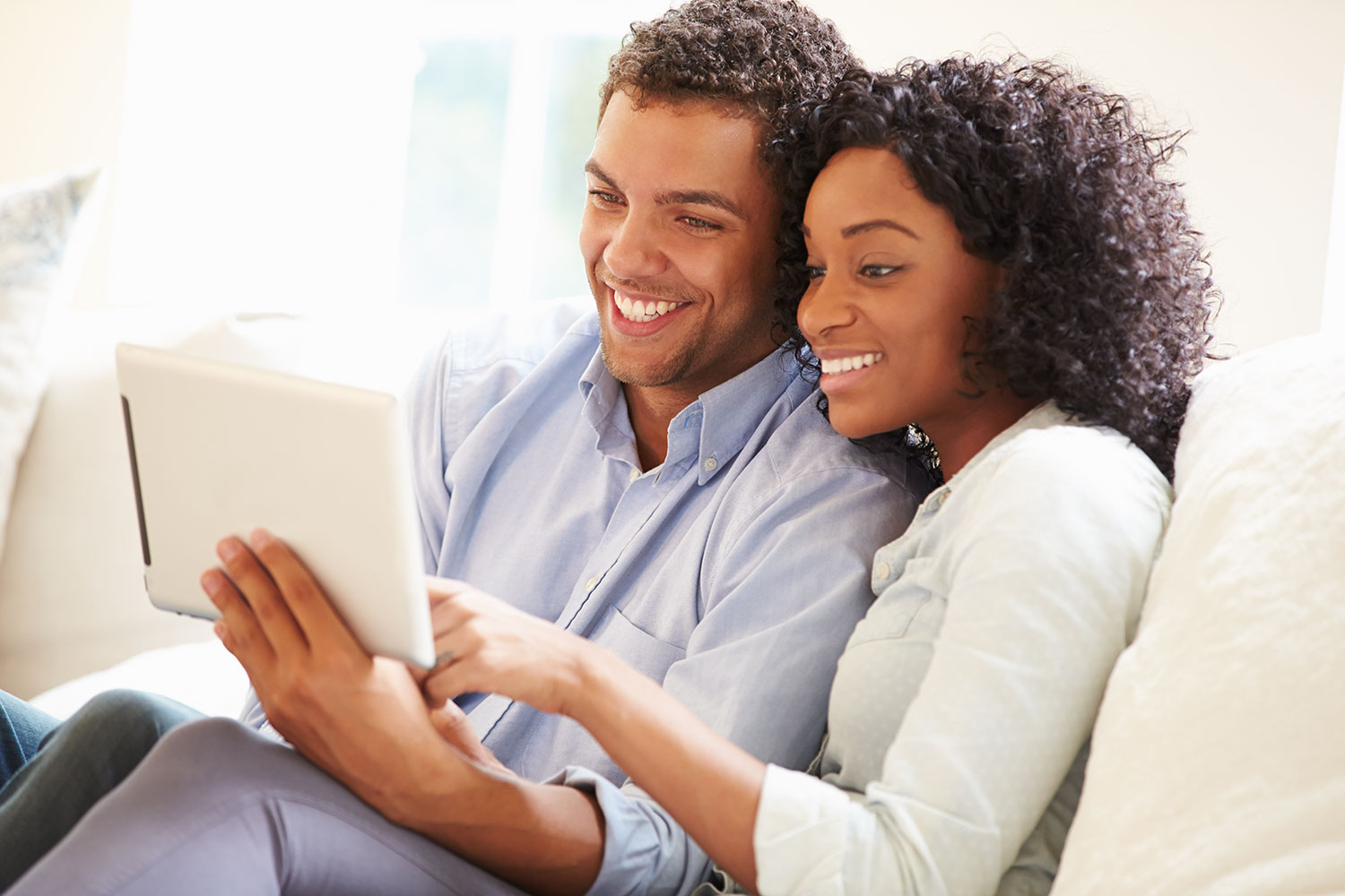 man and woman looking at iPad